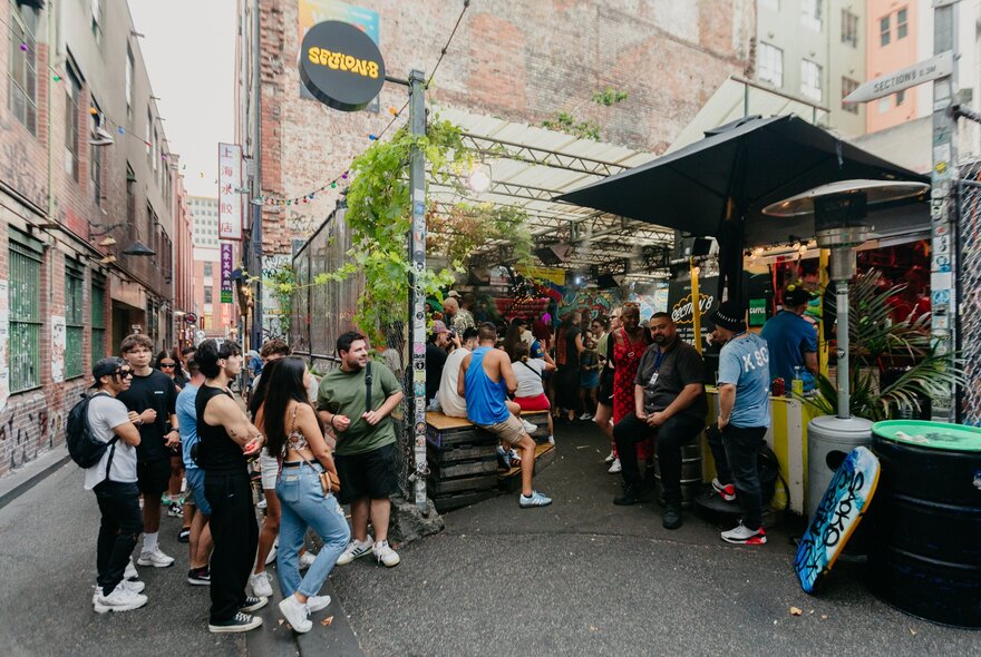 An outdoor bar with people gathered casually in a laneway.