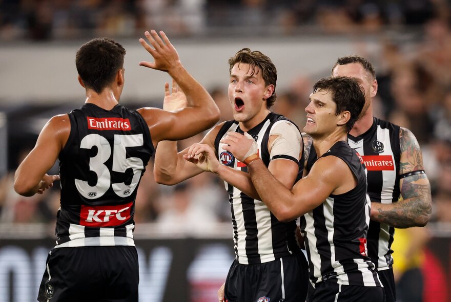 Collingwood AFL football players on the field during a match.
