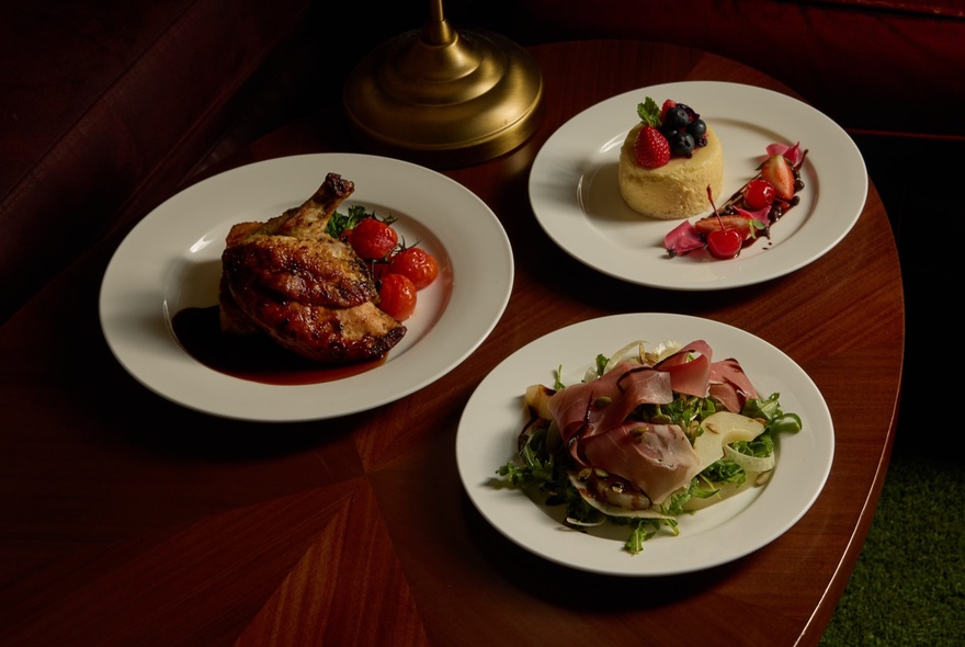 A table with three distinct main courses on white plates.