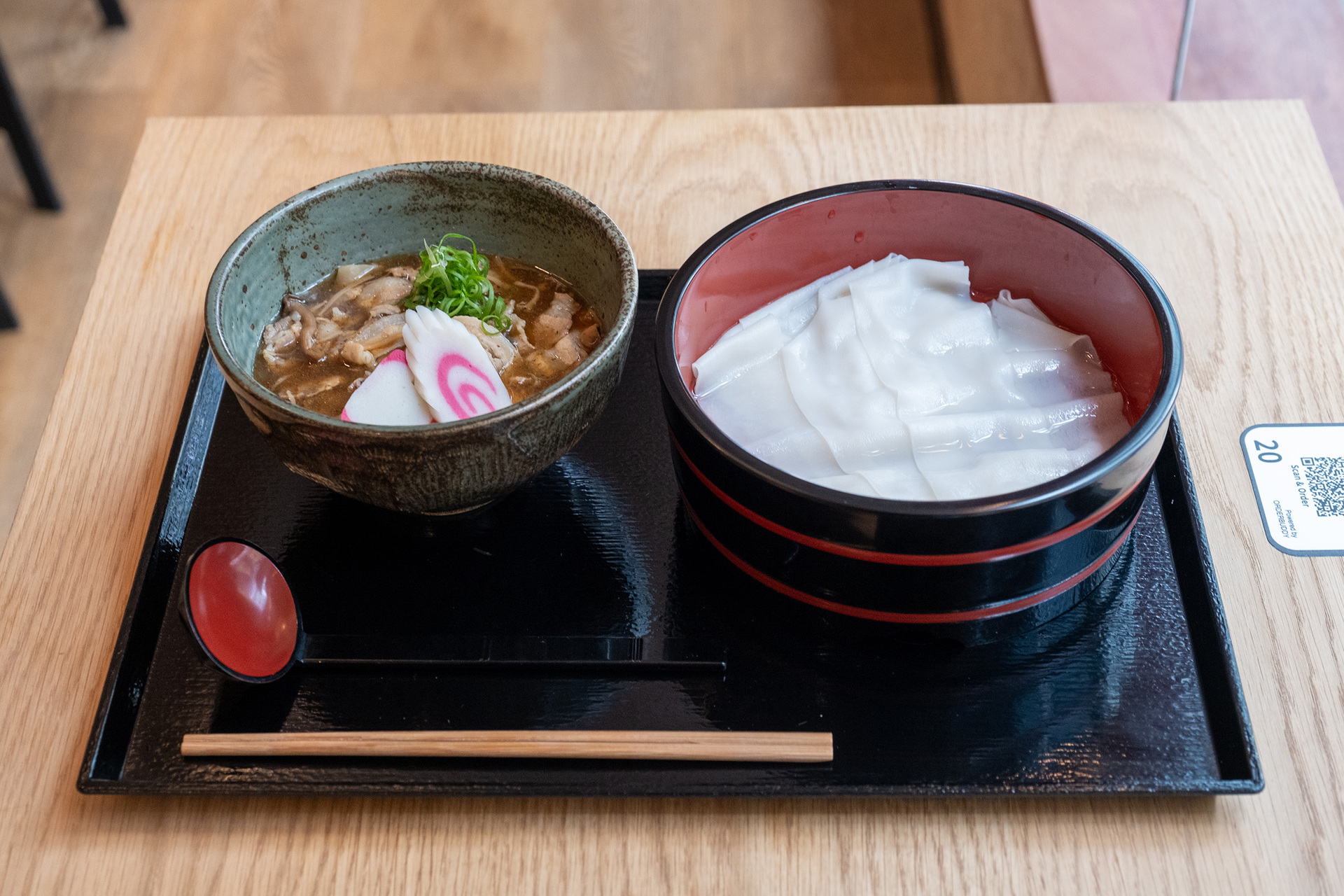 A tray with a bowl of thin udon noodles and another bowl of dipping sauce