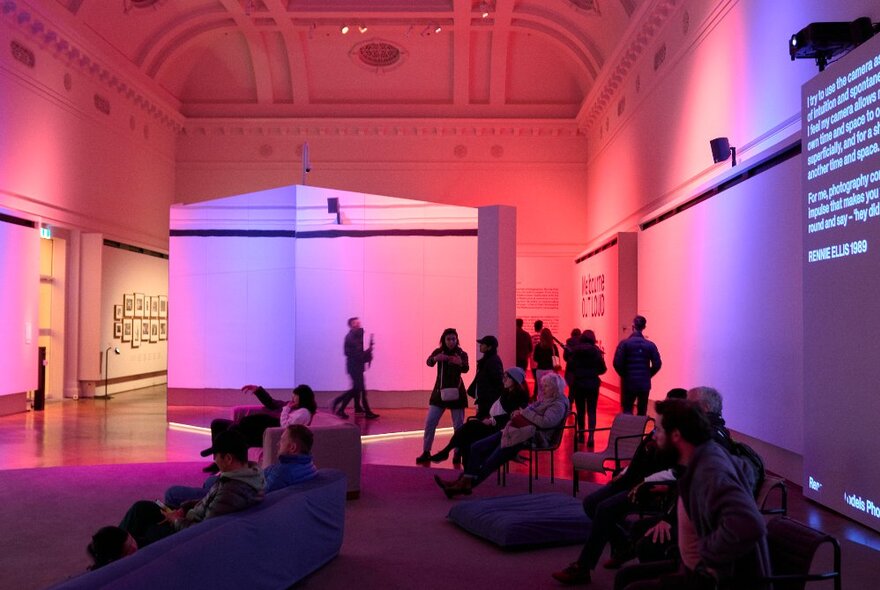 People exploring the interior of a building during Open House Melbourne, some seated on couches, others walking around.