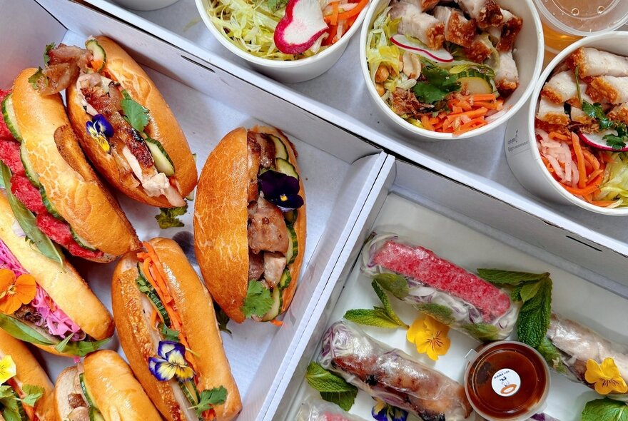 Trays of banh mi sandwiches and bowls of Asian soup.