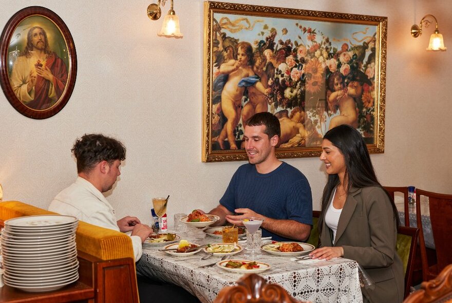 A group of friends are eating an Italian meal at a retro restaurant