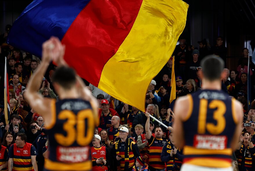 Adelaide Crows AFL football players on the field during a match.