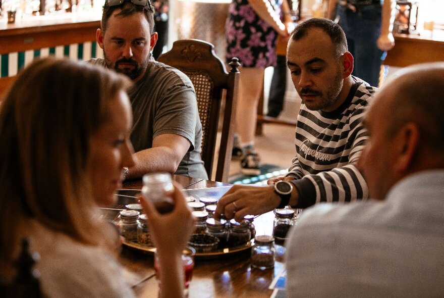 Seated patrons enjoying canapes from a share plate in the centre of the table.