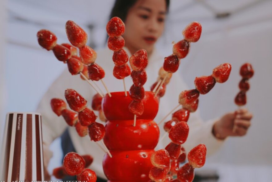 Glazed fresh strawberries on skewers being served at a food stall at the Moon Festival.