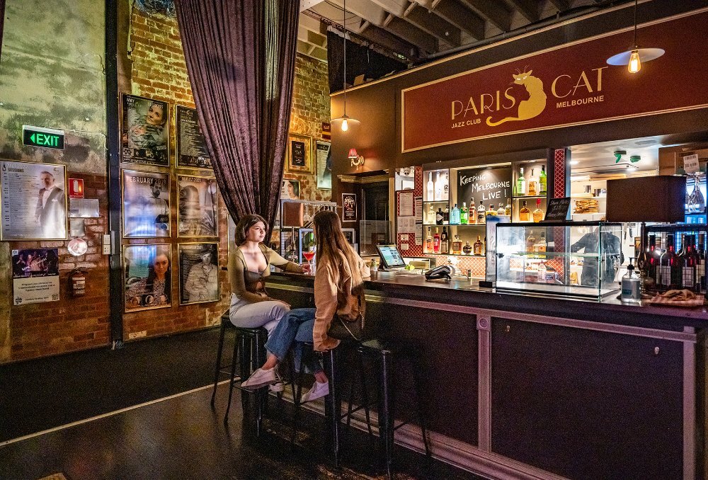 Two women sitting at the bar in a jazz club.