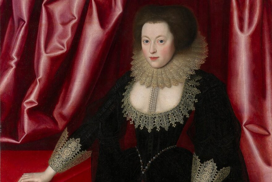 A portrait of a Tudor woman with a ruff around her neck and rose-coloured curtain behind her. 