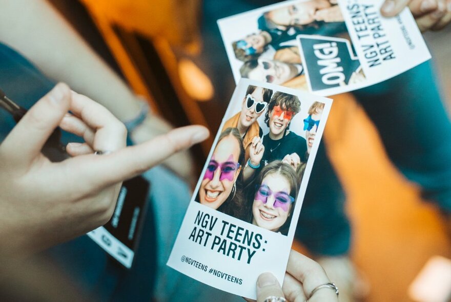 Hands holding tickets to the NGV Teens Art Party.