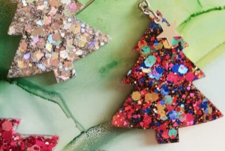 Christmas tree earrings made from colourful resin and sequins.