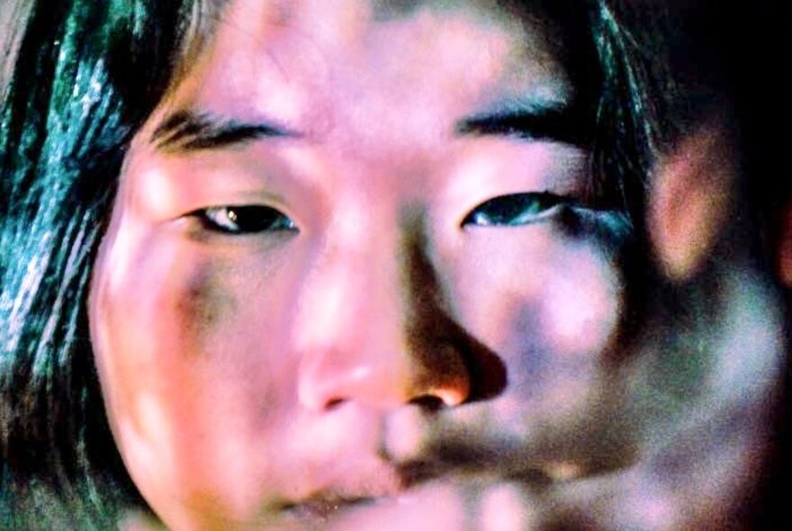 Blurred image of Asian woman's face.