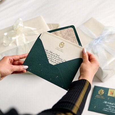 Hands opening up Christmas themed Santa letters against a white background.