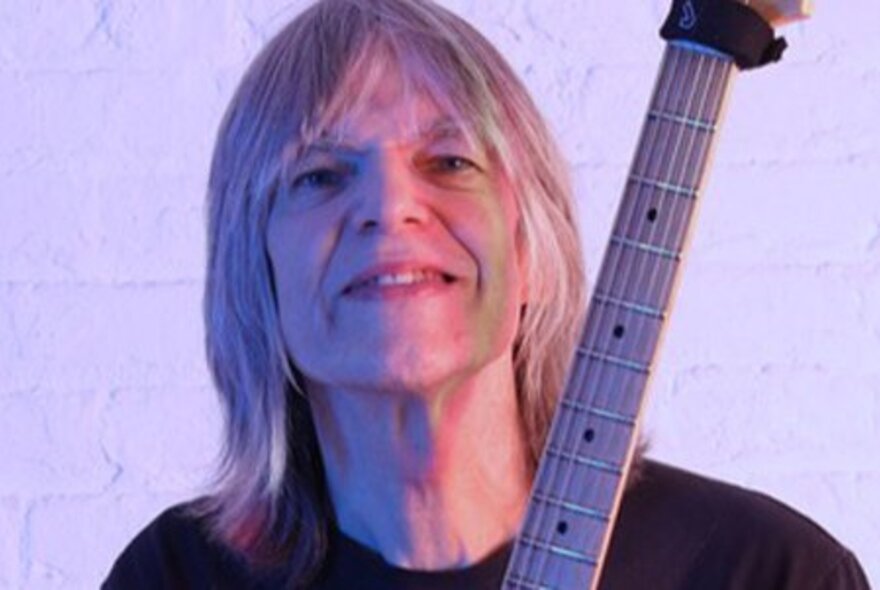 Musician Mike Stern, holding his guitar.
