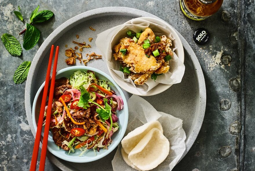 Tray of two Vietnamese dishes with rice crackers.