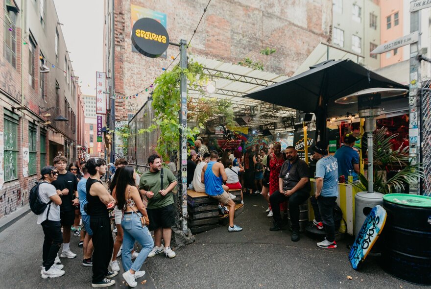 Melbourne's outdoor venue, Section 8, with patrons lining up to get in and others enjoying the bar.