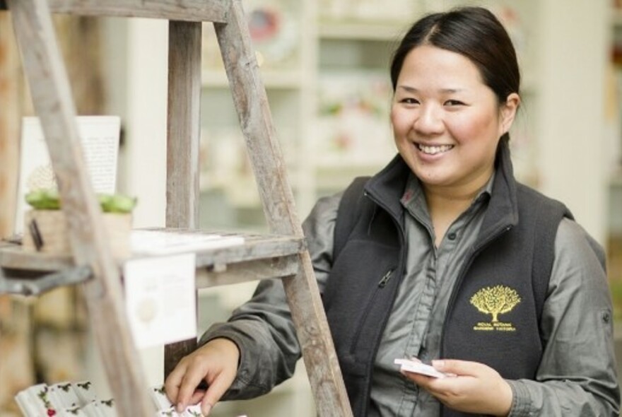 Smiling woman in The Gardens Shop at the Royal Botanic Gardens.