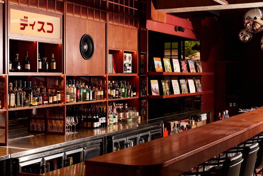 Vintage wood-panelled bar with shelves for bottles and signage.