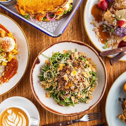 Various brunch dishes and a coffee, viewed from above.