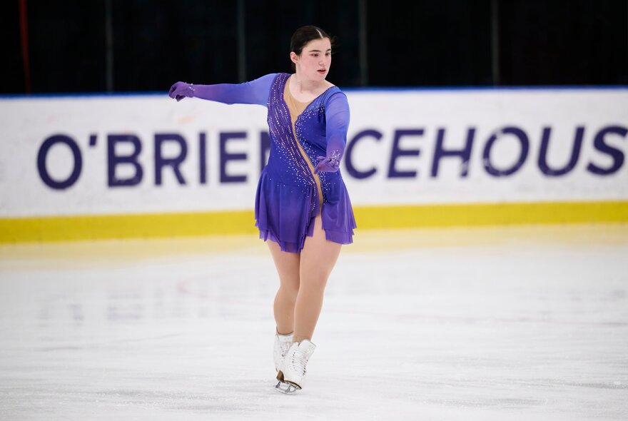 An ice skater in a purple dress on the O'Brien Icehouse rink. 