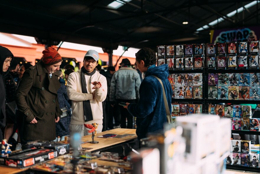 Stalls at the Queen Vic Market selling collectables, with people walking around and browsing.