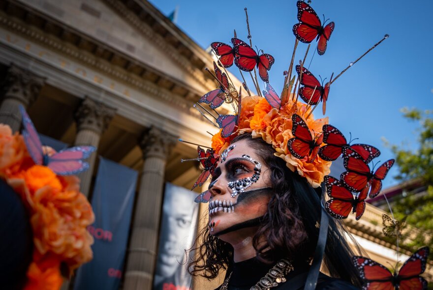 Person wearing Day of the Dead makeup and outfit outside State Library.