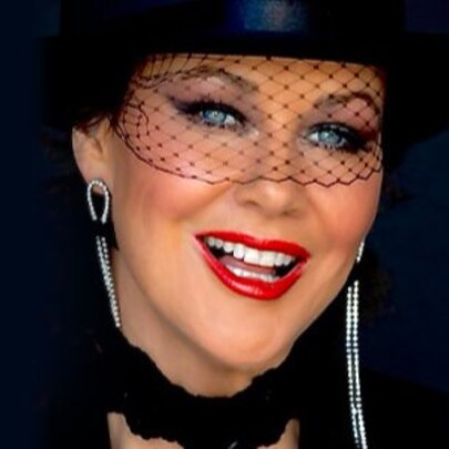 Angie Stapleton dressed as Shania Twain in a black hat and fascinator.