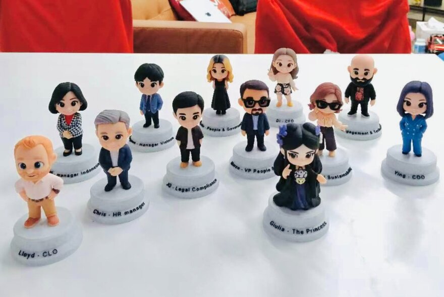 A collection of realistic miniature figurines, each on a little white pedestal, standing on a white tabletop.