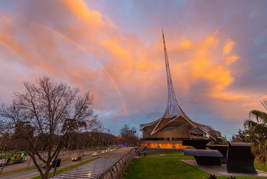The Arts Centre spire on top of a building at sunset.