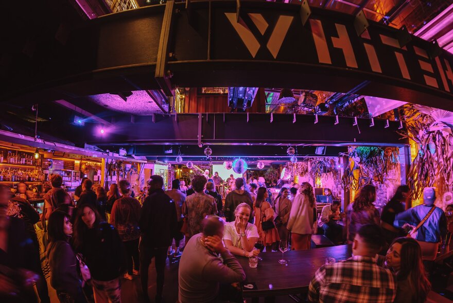 The bustling interior of the Whitehart Bar with patrons enjoying live music and drinks.