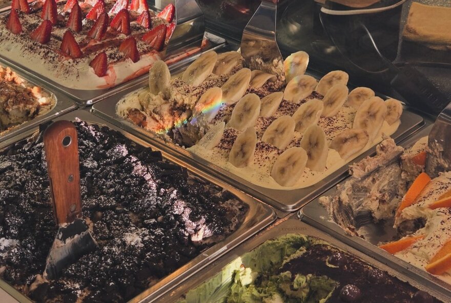 Serving trays of fruit desserts including banana and strawberry trays.