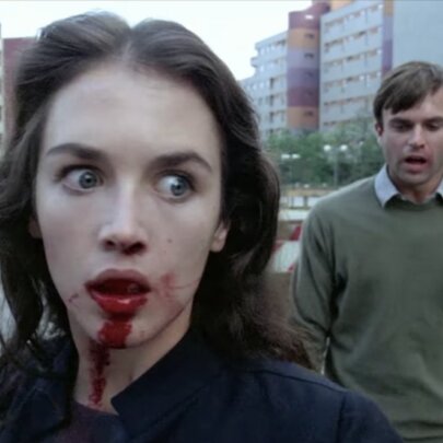 Actress Isabelle Adjani with blood on her face, alongside actor Sam Neill in a tense scene from the psychological horror film Possession.