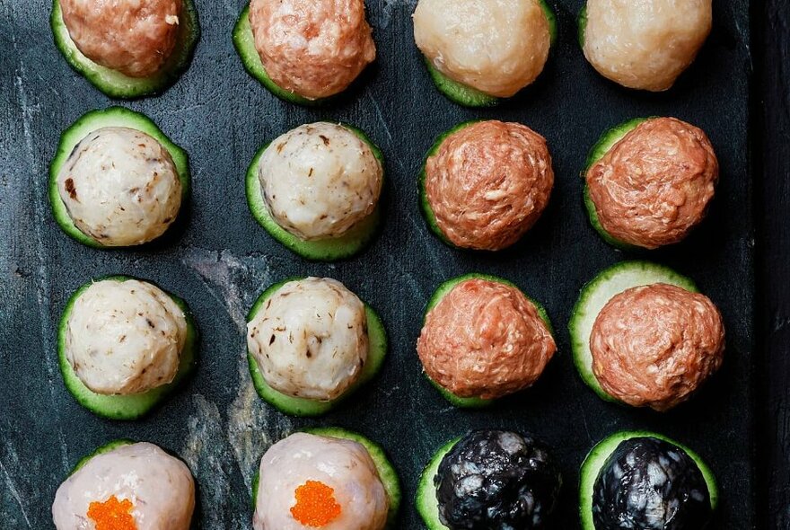 Overhead view of round balls of food waiting to be cooked in a soup hot pot.