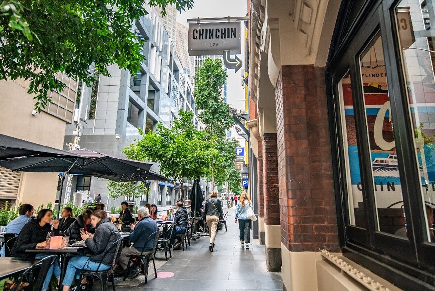 People dining in outdoor laneway.