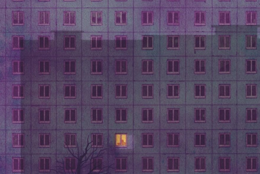 The single, flat facade of a tall and wide apartment building, with rows and rows of the same windows, all blackened except for one that has a light on.