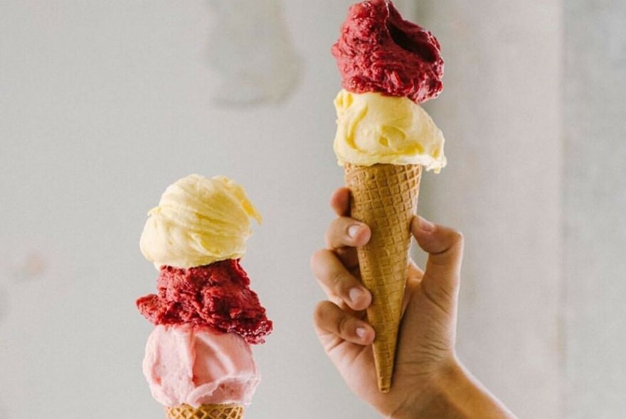 Ice cream cornet with red and white scoops of gelati.