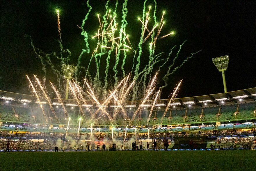 Fireworks going off from the ground at the Melbourne Cricket Ground at night.