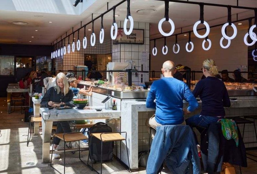 People sitting at a sushi train restaurant