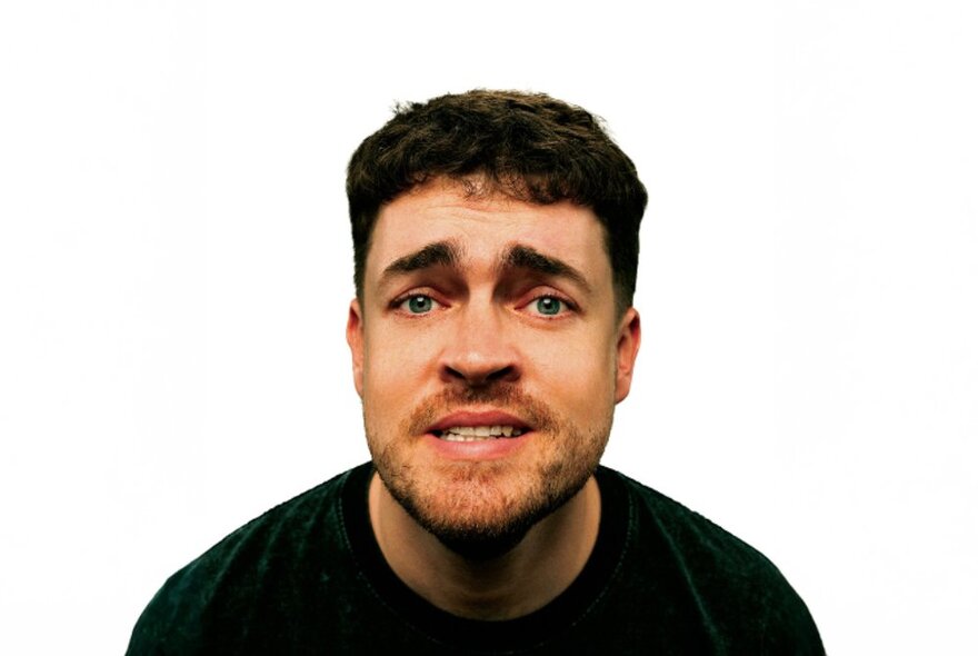 A cut out head shot of comedian Nick White looking slightly pained. 