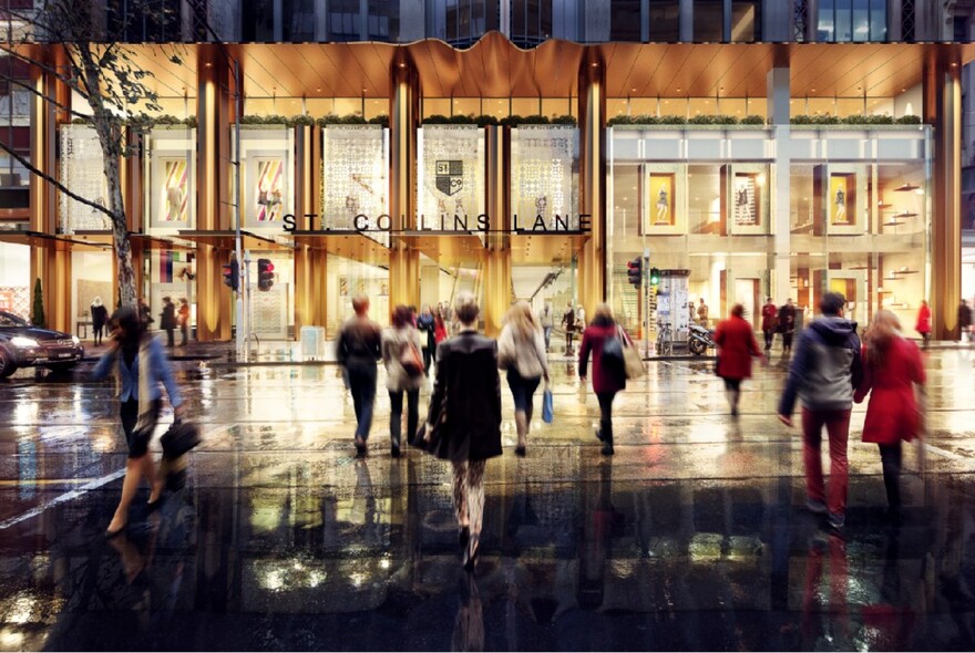 People walking towards St. Collins Lane shopping centra at night.