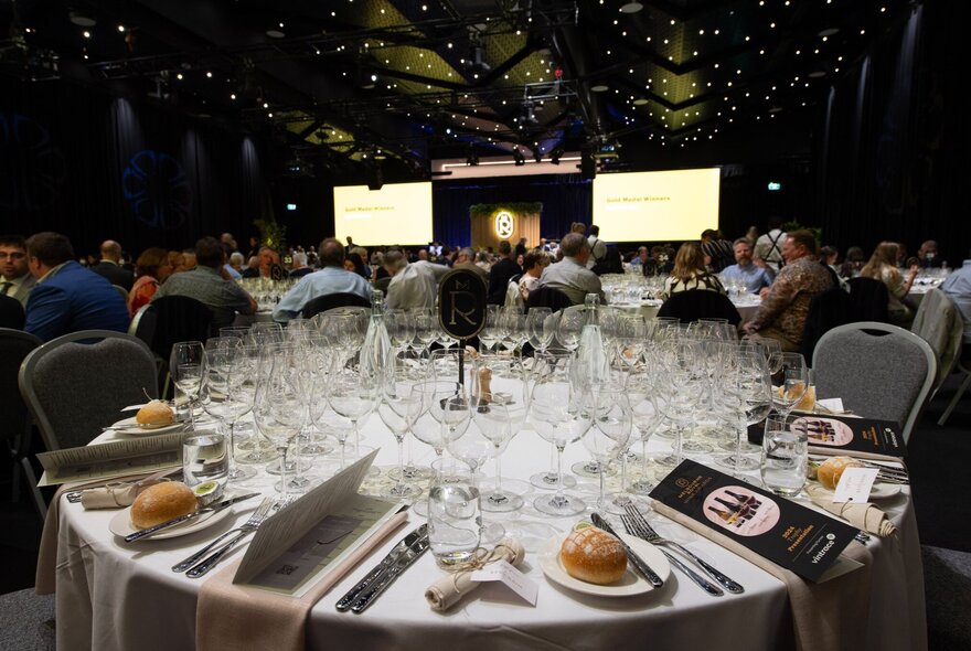 Round table set for a wine dinner with multiple styles of wine glasses.