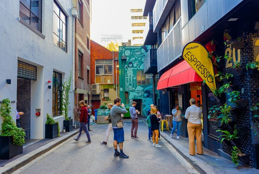 People waiting for coffee outside a laneway cafe. 