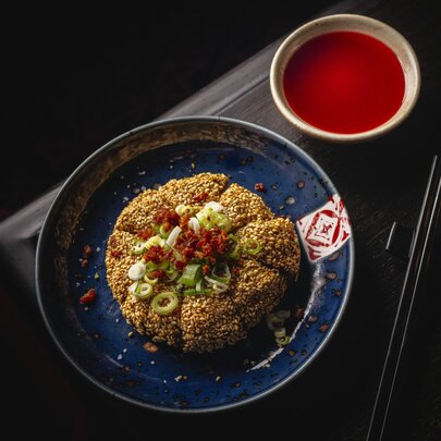 A plate of prawn toast with a red dipping sauce.
