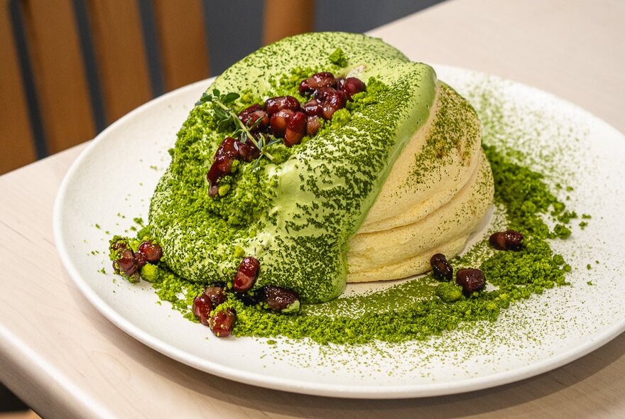 Souffle-style fluffy pancakes with pistachio cream and a dusting of cocoa.