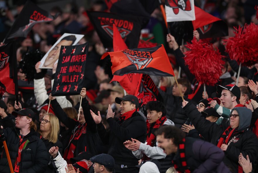 Essendon fans in the stands with banners.