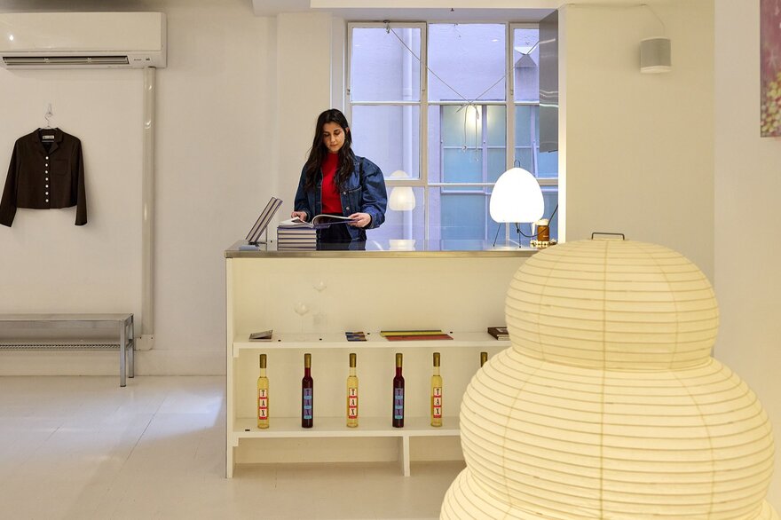 A woman browsing in a stylish home decor and fashion boutique. A giant paper lamp is in the foreground.