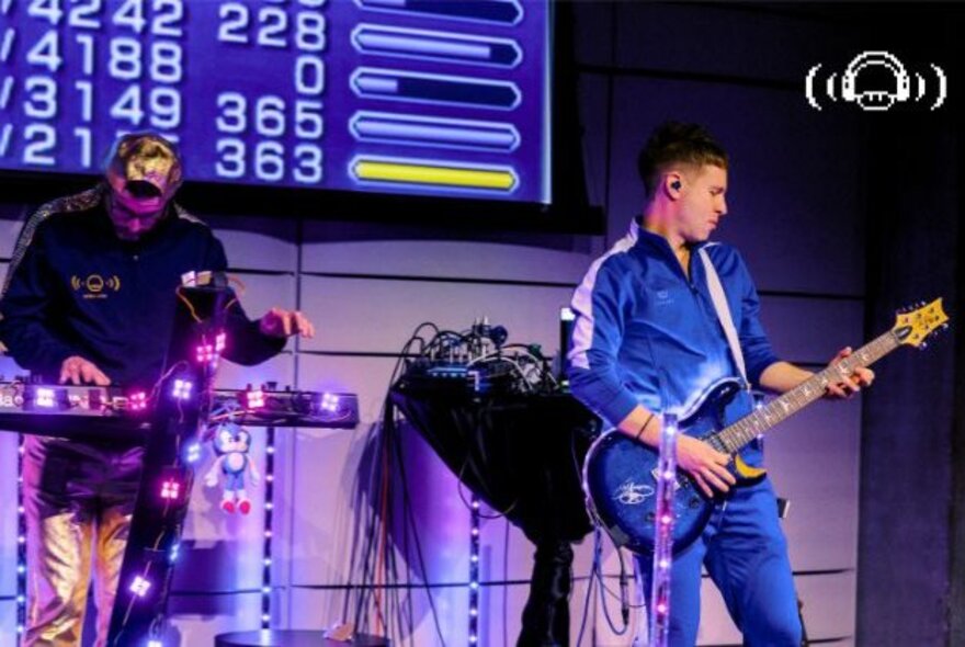 The interactive video-game concert and live audience role-playing game called Extra Lives, with a musical band playing live on stage in front of a large monitor.