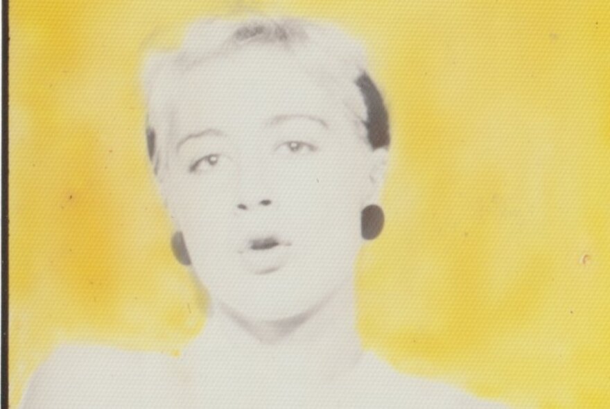 A photobooth portrait of a woman with short hair from the 1980s; gelatin silver print with yellow ink.