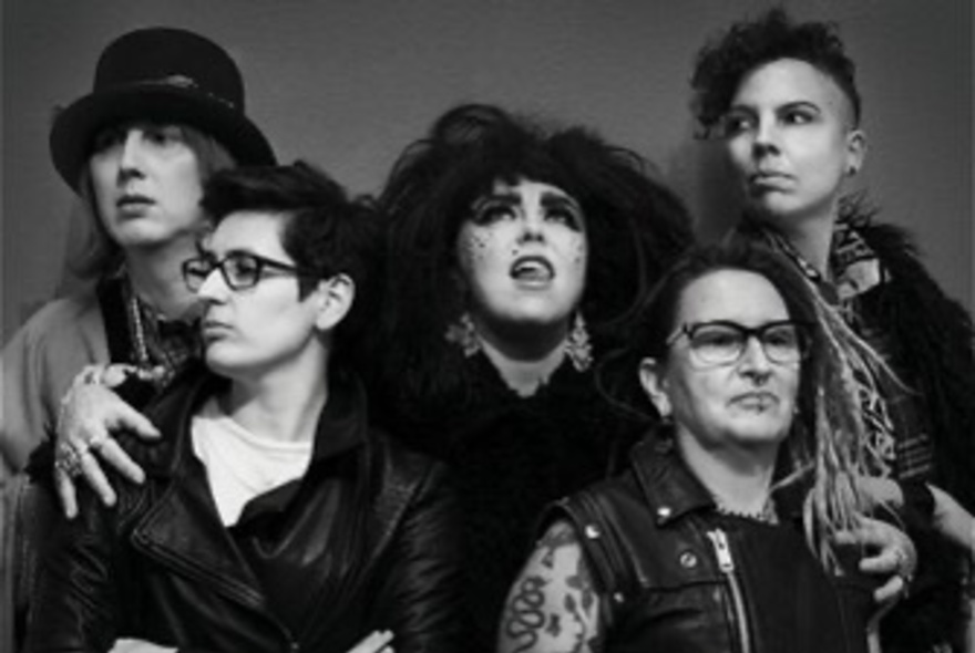 Five women dressed like a rock band.
