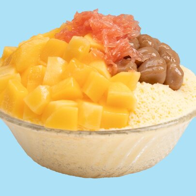 A mango bingsu, with fresh chopped mango and taro ball topping over shaved ice.