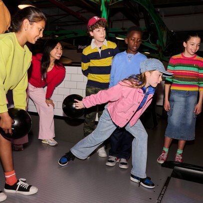 A group of kids bowling at an alley.
